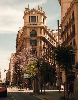 Historic building along a tree-lined street in central Barcelona.