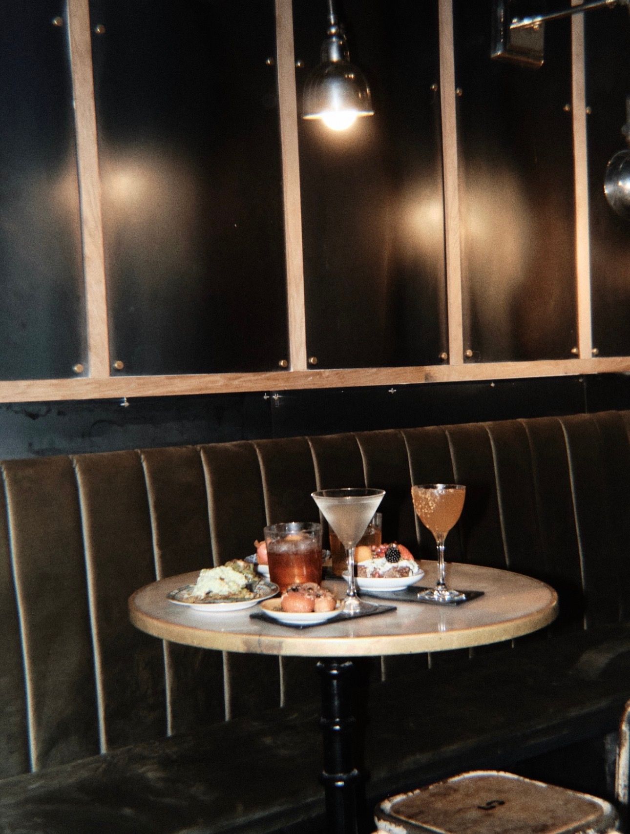 Cocktails and small plates served on a table inside Two Schmucks bar in Barcelona.