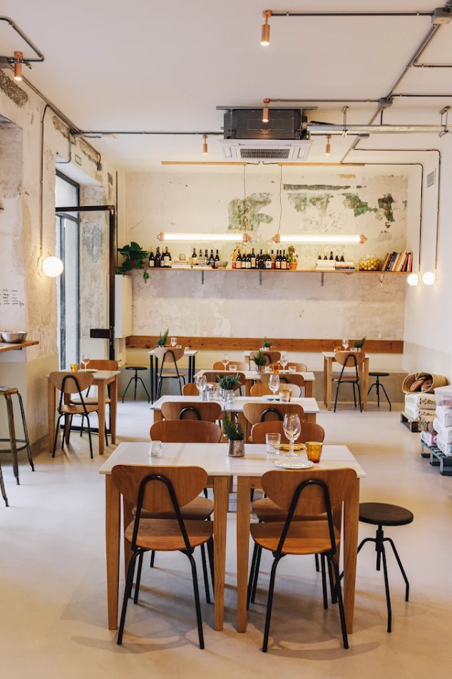 Interior of La Balabusta restaurant in Barcelona, featuring wooden tables, minimalist décor, and a bright contemporary dining space.
